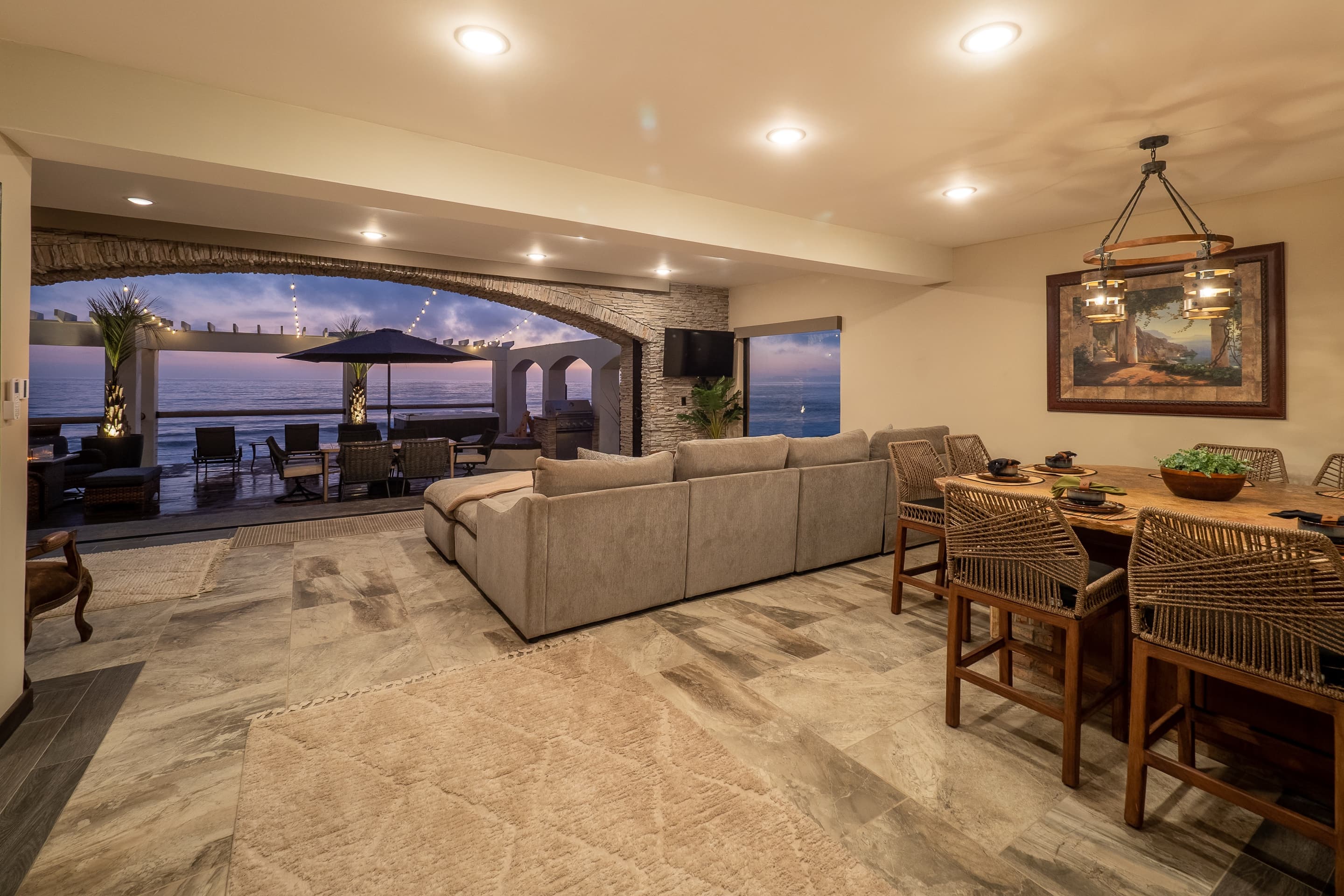 Open living and dining room with travertine floors and ocean view