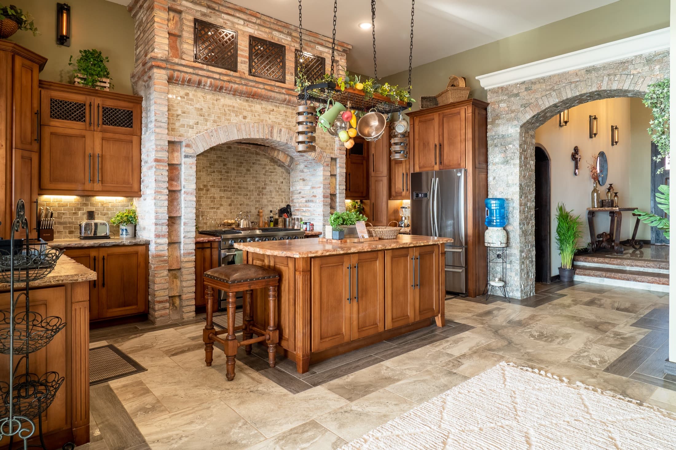 Chef's kitchen with brick arches and a center island